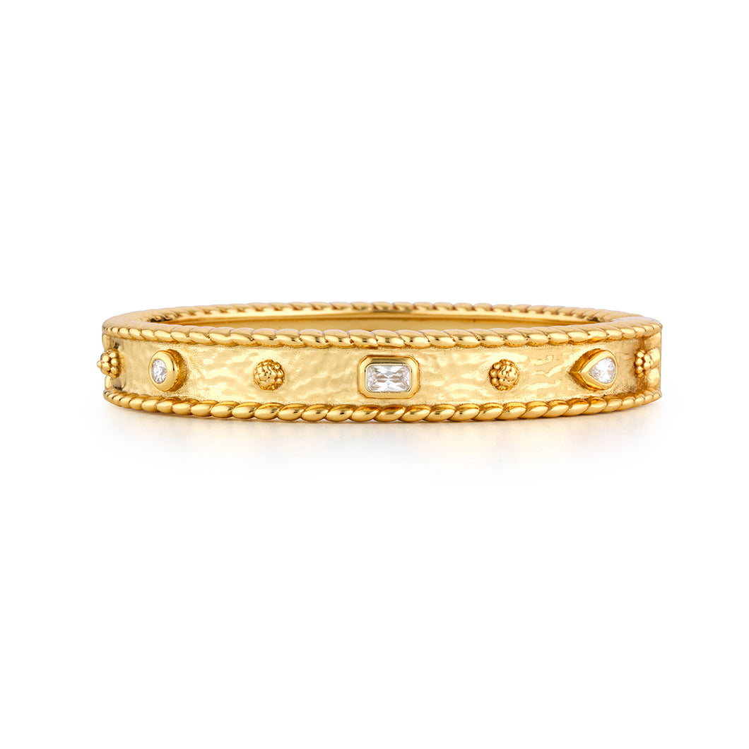 A gold band adorned with diamonds on the side, featuring the Berry Gem Hinged Bangle with clear cubic zirconia accents.