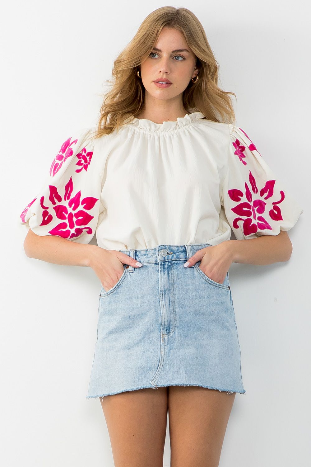 Experience the perfect blend of comfort and style with the Alice Corduroy Top. This white blouse with pink floral patterns is a statement piece, showcasing intricate embroidery on the sleeves.